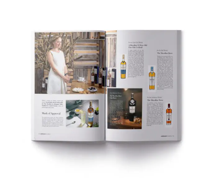A woman in a white dress poses elegantly beside an array of wine bottles featured in the magazine